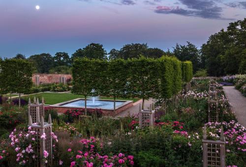 a garden with flowers and a pool in the middle at Woodlands Cottage, Wynyard Hall in Grindon
