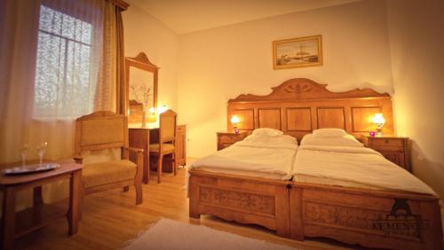 ハイドゥソボスローにあるKemencés Csárda és Panzióのベッドルーム1室(ベッド1台、テーブル、椅子付)