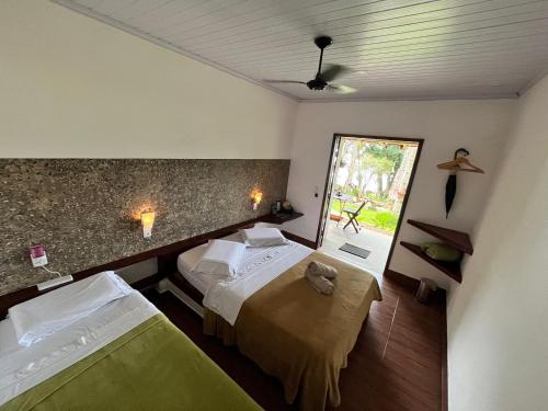 a hotel room with two beds and a window at Fauna in Praia do Bananal