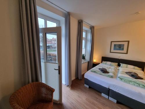 um quarto com uma cama e uma grande janela em Villa Schönfeld Wohnung 1 em Papenburg