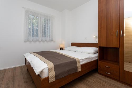 a bedroom with a bed and a window at Apartments Crneković V in Baška