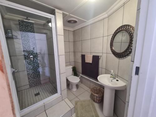 ein Bad mit einer Dusche, einem WC und einem Waschbecken in der Unterkunft The Fellows Guest Accommodation in Postmasburg