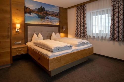- une chambre avec un lit orné d'une peinture murale dans l'établissement Gidis Hof, à Ischgl