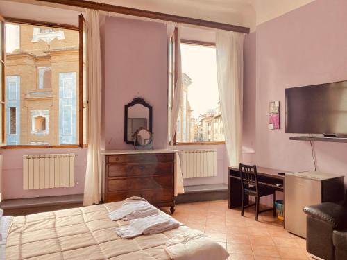 a bedroom with a bed and a desk and a television at Emerald Palace Family Hostel in Florence