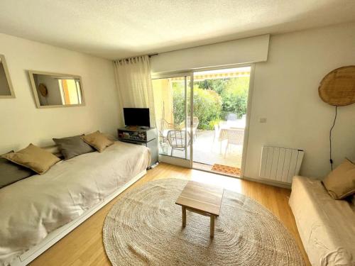 a living room with two beds and a table at Appartement rénové à Cavalière avec terrasse in Le Lavandou