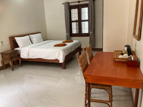 a bedroom with a bed and a wooden table at Lily Pad Boutique Hotel in Siem Reap