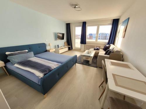 1 dormitorio con 1 cama azul y sala de estar en Ferienwohnung Seestern Geeste, en Bremerhaven