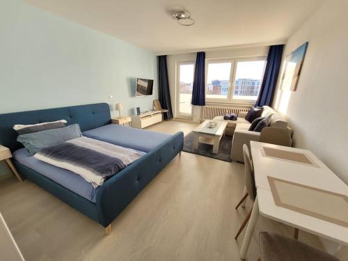a bedroom with a blue bed and a living room at Ferienwohnung Seestern Geeste in Bremerhaven