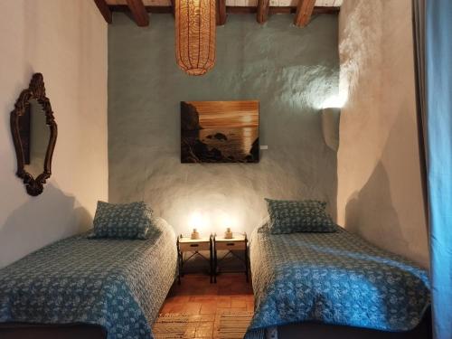 Sobrestany的住宿－Mas Del Llop Blanc - Dog friendly Hostal Rural - B&B，一间卧室设有两张床和一张带蜡烛的桌子。