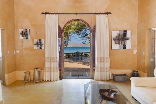 a living room with an open door with a view of the ocean at Villa Es Morer in Alcudia
