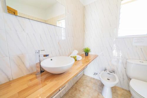 a white bathroom with a sink and a toilet at Villa Es Morer in Alcudia