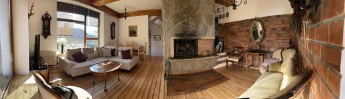 a living room with a fireplace and a couch at Willa Art Deco in Ustroń