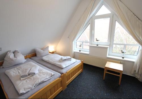 Habitación con 2 camas individuales y ventana grande. en Karkpolder Residenz Haus 3, en Langeoog