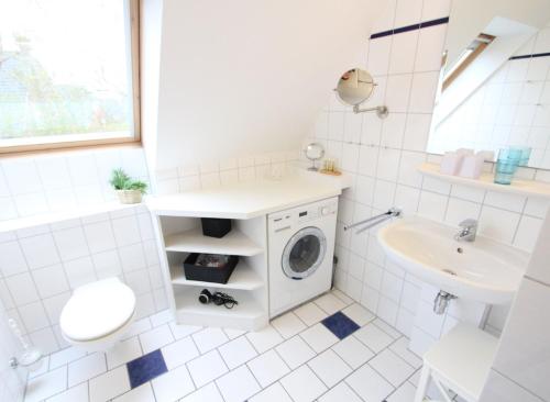 a bathroom with a washing machine and a sink at Karkpolder Residenz Haus 3 in Langeoog