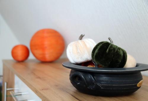 a black bowl filled with pumpkins on a table at Haus Silvia in Gostorf