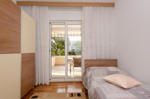 a bedroom with a bed and a sliding glass door at Apartments Bungavilia in Rovinj