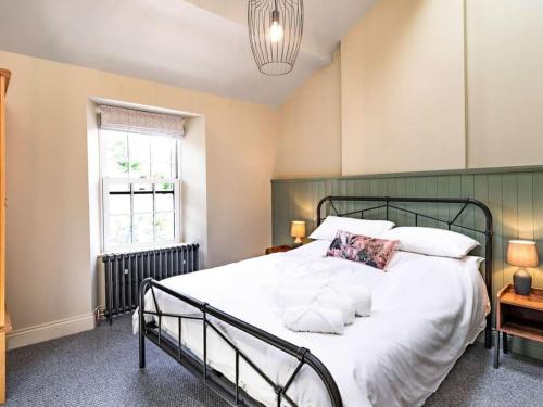 1 dormitorio con cama y ventana en Northdene - 5 star Lake District Cottage en Cockermouth