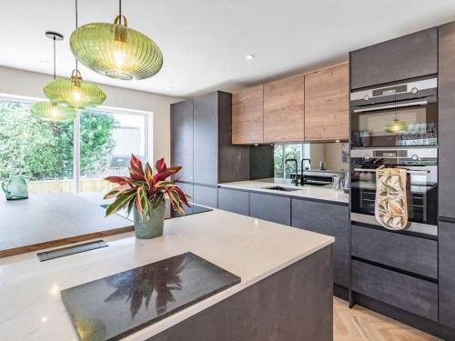 a kitchen with a large island with a potted plant at Northdene - 5 star Lake District Cottage in Cockermouth