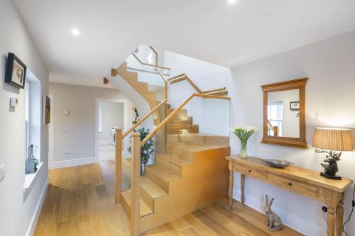 escalera en la sala de estar con mesa de madera y espejo en Greenmyre Farmhouse with Hot Tub en Kirriemuir