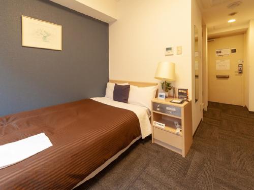 東京的住宿－HOTEL LiVEMAX BUDGET Shinbashi，酒店客房设有一张大床和一盏灯。