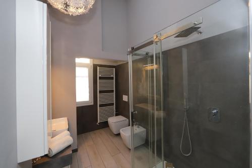 a bathroom with a glass shower and a toilet at Loggia del Tenore Suite in Modena