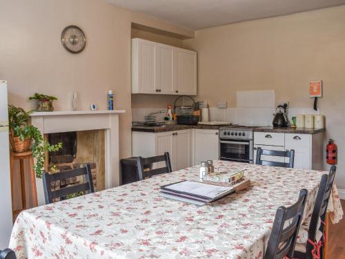 uma cozinha com uma mesa com uma toalha de mesa em Wards Court 2 - Uk41275 em Frampton on Severn