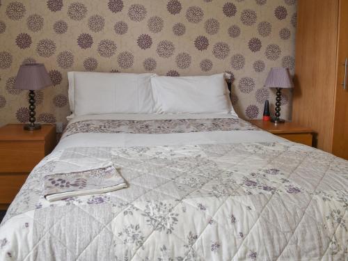 a bed with a white comforter and two lamps at Wards Court 2 - Uk41275 in Frampton on Severn