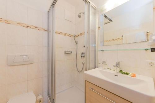 uma casa de banho com um chuveiro, um lavatório e um WC. em Hotel - Pension Ötzmooshof em Sankt Johann im Pongau