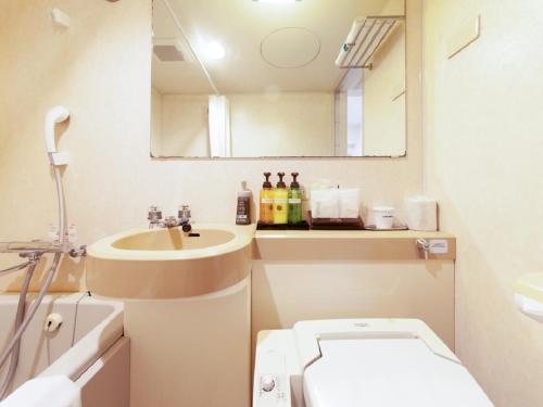 a small bathroom with a sink and a toilet at HOTEL LiVEMAX BUDGET Shinbashi in Tokyo