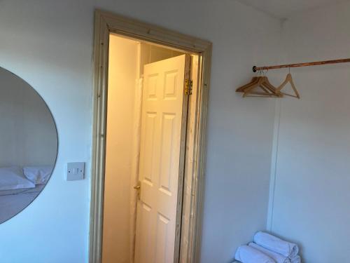 an open white door in a room with a mirror at 2 Double Rooms and Double AIrbed in Dublin