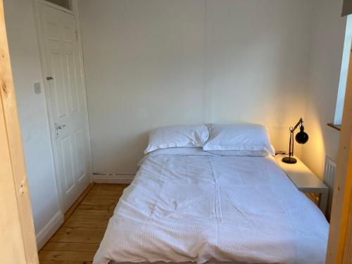a bed in a room with a white wall at 2 Double Rooms and Double AIrbed in Dublin