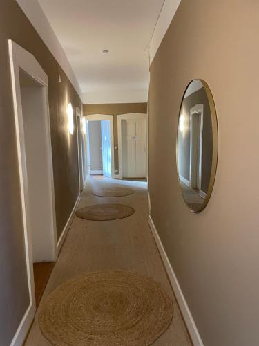 a hallway with a mirror on a wall with rugs at AUERSTEIN-Hotels auerstein & auerstein-mono in Heidelberg