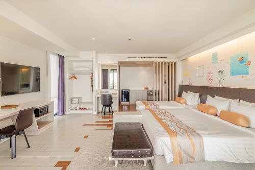 a bedroom with a large bed and a living room at Sand Dunes Chaolao Beach Resort in Chao Lao Beach