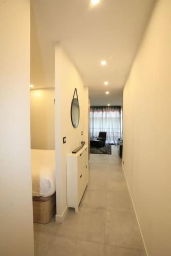 Cette chambre blanche comprend un lit et un miroir. dans l'établissement Appartement avec balcon Supercroisette, à Cannes