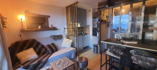 ein Wohnzimmer mit einem Sofa und einer Küche in der Unterkunft Studio montagnard vue splendide ALPE D HUEZ LES PASSEAUX in L'Alpe-d'Huez