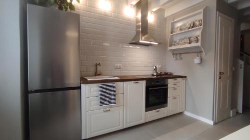 een keuken met witte kasten en een koelkast bij Marietta's House in Rhodos-stad