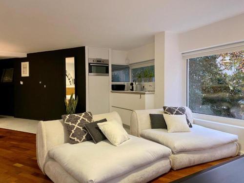 a living room with two white couches and a window at Mosaikon Guesthouses #Aiolou Str in Athens