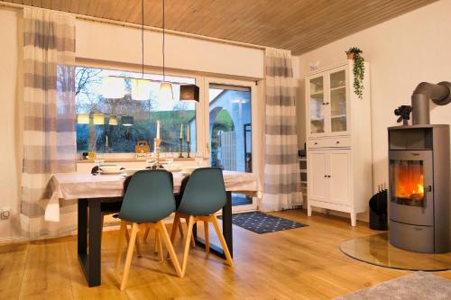 a kitchen with a table and chairs and a fireplace at Apfelhaus beim Hennesee in Meschede