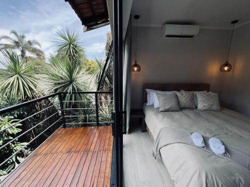 a bedroom with a bed and a balcony with palm trees at Panorama Guest House in Johannesburg