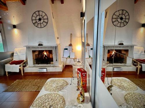 een woonkamer met een open haard en klokken aan de muur bij La Hacienda Apartments Belgrade in Draževac