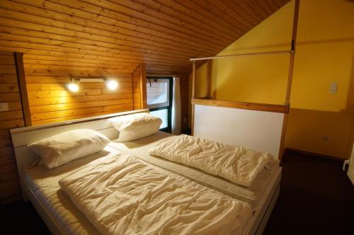 a bedroom with a bed with two pillows at Terrassenpark Apartments (low budget) in Sasbachwalden