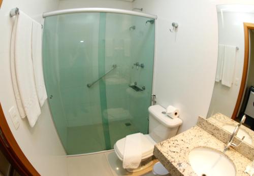 a bathroom with a shower and a toilet and a sink at Hotel Financial in Belo Horizonte