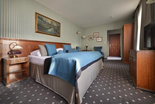 a hotel room with a large bed and a television at Hotel Morris Premium Collection in Česká Lípa