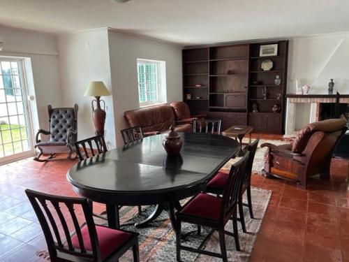 a living room with a table and chairs at Solar das Mimosas 2 casas in Sintra