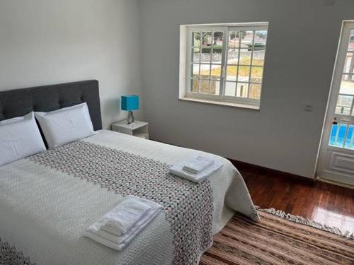 een slaapkamer met een bed en een raam bij Solar das Mimosas 2 casas in Sintra