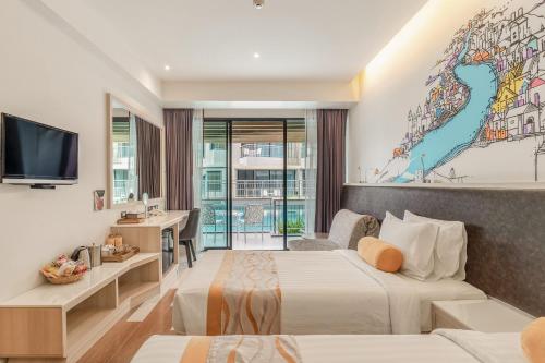 a hotel room with two beds and a tv at Sand Dunes Chaolao Beach Resort in Chao Lao Beach