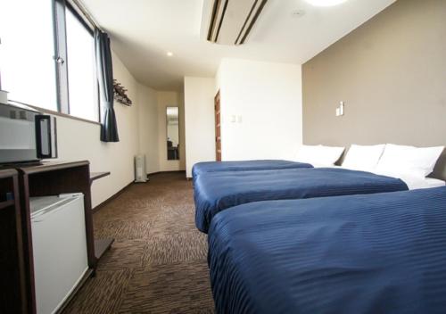 Cette chambre comprend 2 lits et une télévision à écran plat. dans l'établissement HOTEL LiVEMAX BUDGET Gunma Numata, à Numata