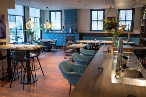 a restaurant with a bar and tables and chairs at Hotel Grandcafe De Doelen in Franeker