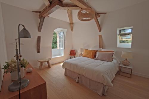 sypialnia z dużym łóżkiem i drewnianą podłogą w obiekcie Orangerie de la Touchardière w mieście Durtal