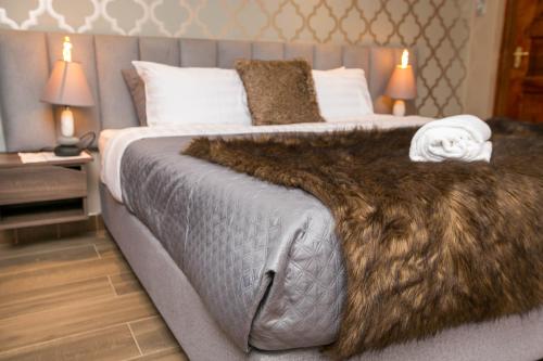 a bedroom with a large bed with a fur blanket at 41 Haven in Nairobi